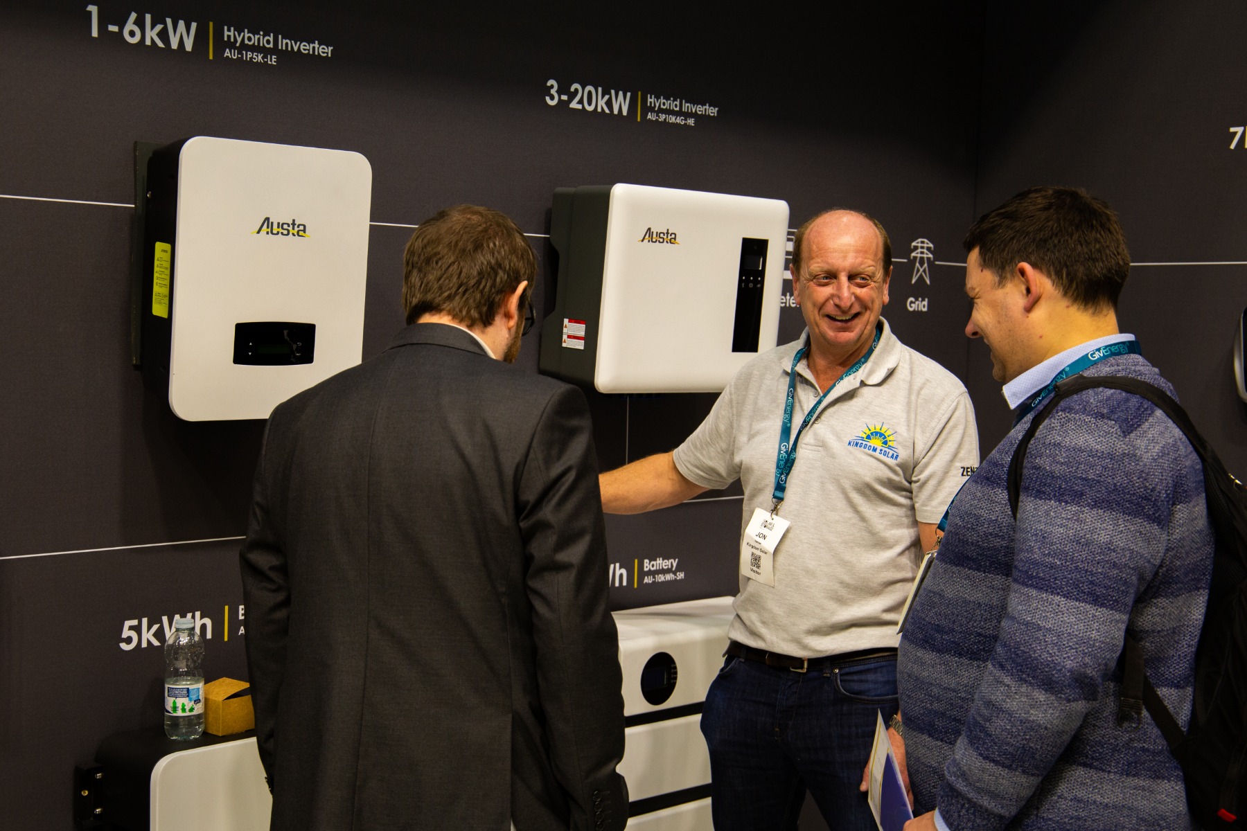 Kingdom Solar representative showing customers Austa Micro and Hybrid Inverters at Solar Trade Show